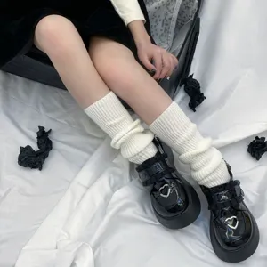 White knit leg warmers detail shot showing cozy winter style outfit with platform shoes.