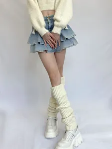 Detailed view of white knitted thick stripe leg warmers, cozy winter JK style fashion accessory.