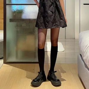 Detailed shot of sheer black splice knee high socks, fashionable leg wear and apparel styling.