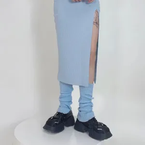Detail view of light blue knit leg warmers, showing cozy autumn and winter fashion style.
