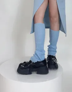 Detailed view of soft knit leg warmers in light blue, perfect for autumn and winter outfits.