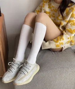 Detailed view of fashionable white high socks for women, soft and comfortable knit hosiery.