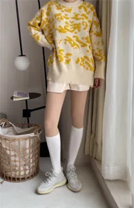 Sweet cool style sweater outfit detail featuring patterned knit top and white knee socks.
