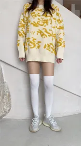 Knit sweater and white over-the-knee socks detail shot, showcasing trendy daily outfit style.