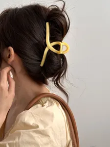 Vue détaillée d'une pince à cheveux jaune clair élégante pour un look quotidien chic.