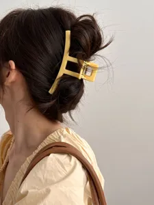 Vue détaillée d'une pince à cheveux jaune élégante, idéale pour les coiffures chics.