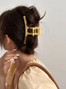 Détail pince à cheveux jaune, accessoire uni élégant pour coiffure quotidienne chic et mode.