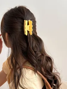 Pince à cheveux jaune pour femme, design uni ondulé, accessoire de coiffure quotidien.