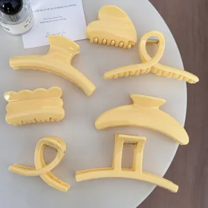 Vue détaillée de pinces à cheveux unies jaune vif tendance pour des coiffures élégantes et stylées.
