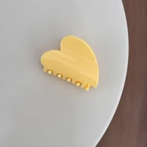 Pince à cheveux cœur jaune vif, accessoire capillaire unicolore brillant et élégant au quotidien.