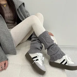 Gros plan de collants en tricot losange ajouré et de jambières grises avec baskets rétro décontractées.