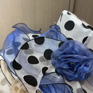 Nahaufnahme Detail des eleganten Damen Organza Sonnenhuts mit Punkten und blauer Blume Sommer.