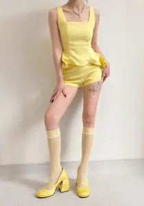 Yellow lace-trimmed knee-high socks detail shot, fashionable spring leg wear accessory.