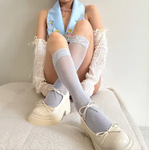 Women's light blue lace mid-tube socks paired with white platform mary jane shoes and sleeves.