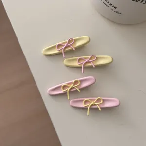 Dettaglio mollette per capelli con fiocco stile coreano, accessori pastello rosa e giallo.