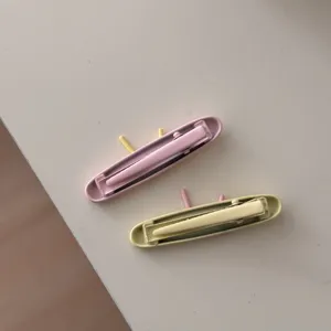 Primo piano dettagliato di fermagli per capelli rosa e gialli disposti ordinatamente sul tavolo.