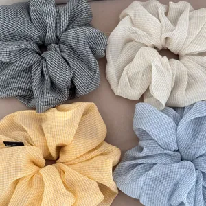 Detail shot of plaid chiffon scrunchies showcasing the soft fabric texture and pleats.
