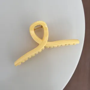 Pince à cheveux jaune uni pour femme, design torsadé et ressort métallique au quotidien.