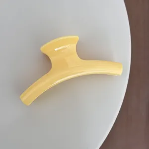 Gros plan d'une pince à cheveux jaune élégante, design simple et épuré pour le coiffage quotidien.