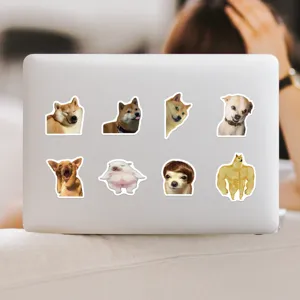Close up view of funny dog meme stickers applied on a white laptop surface for daily decor.