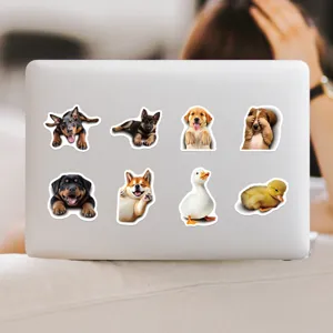 Detailed view of cute pet animal stickers featuring adorable dogs and ducks on a laptop lid.