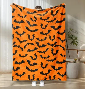 Halloween orange flannel blanket with black bat print, soft plush throw for autumn decor.