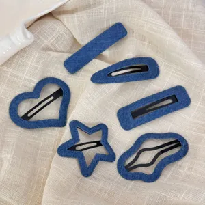 Detailopname van de blauwe denim haarspeldjes set met schattige hart en ster vormen.