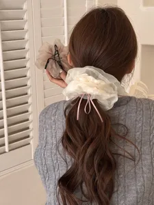 Elegante scrunchie in rete con nastro rosa, ideale per acconciature stile balletto chic.