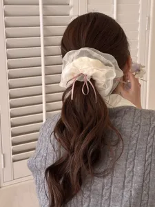 Elastico per capelli in organza bianca con fiocco rosa, dettaglio elegante per acconciature.