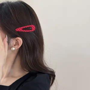 Rode stippen stoffen haarspeld detailweergave, schattig accessoire voor dagelijkse styling.