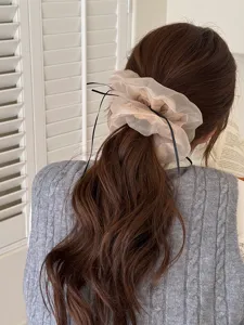 Primo piano dettagliato di un elastico per capelli in tulle balletcore legato alla coda.
