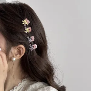 Detail shot of mini bow hair claw clips worn on side hair, cute acrylic styling accessory.
