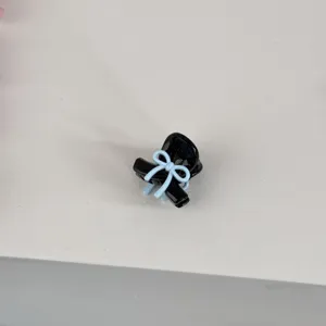 Close-up of a cute mini black hair claw clip featuring a sweet light blue bow design.