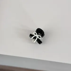 Close-up detail of the mini black bow hair claw clip, perfect for cute styling.
