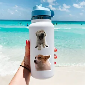 Stainless steel insulated water bottle with cute puppy stickers, outdoor beach scene display detail.