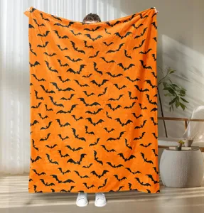 Detail view of Halloween bat printed orange flannel blanket, cozy throw blanket for home decor.