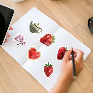 Detail view of waterproof strawberry graffiti stickers set on a notebook, perfect for cups and phones.