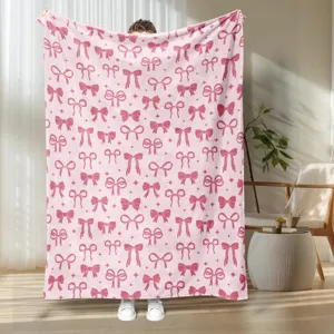 Cozy pink flannel blanket featuring a cute bow print, perfect for bedroom and living room decor.