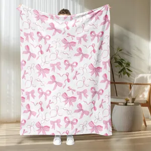 Cozy pink bow print flannel blanket for bed or sofa, soft plush throw blanket for warm home decor.