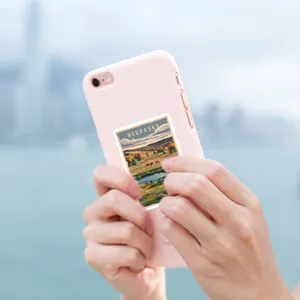 Close up detail of a vintage Nebraska travel poster sticker attached to a cute pink phone case.