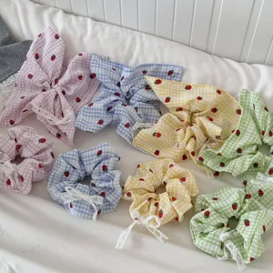 Set di scrunchies per capelli e foulard quadrati in tessuto a quadretti fragola, dettaglio.