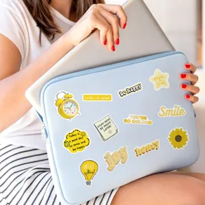 Adesivi motivazionali gialli impermeabili in dettaglio su custodia per laptop con graffiti.