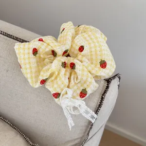 Elastico per capelli a quadri gialli con fragole e dettaglio fiocco in pizzo bianco.