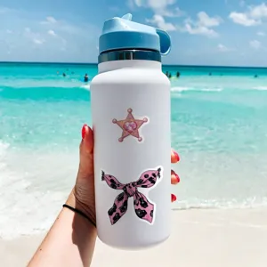Stainless steel water bottle with cute pink magical girl and bow stickers on beach background.