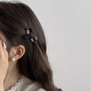 Detail view of cute mini bow hair claw clips worn on side hair, stylish and sweet accessory.