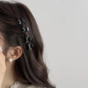 Detailed view of cute black mini hair claw clips with silver bows for side bangs styling.