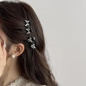 Detail of cute black and silver bow mini hair claw clips for side bangs and styling.