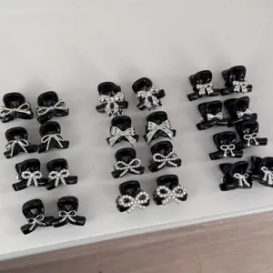 Detailed view of cute black mini hair claw clips with silver bow and rhinestones for daily use.