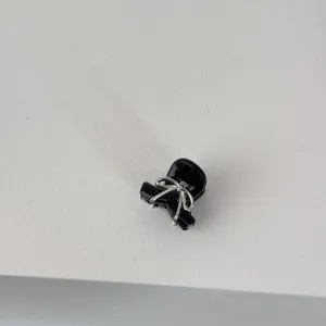 Close-up detail of the cute black mini hair claw clip featuring a delicate silver bow.