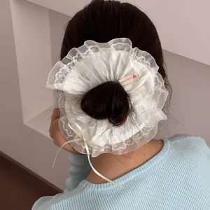 Elegantes weißes Spitzen-Haargummi mit hübscher Schleife, ideal für stilvolle Dutt-Frisuren.